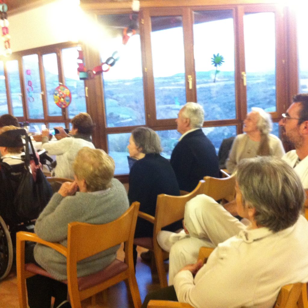 Residentes y familias reunidos en la sala con vistas